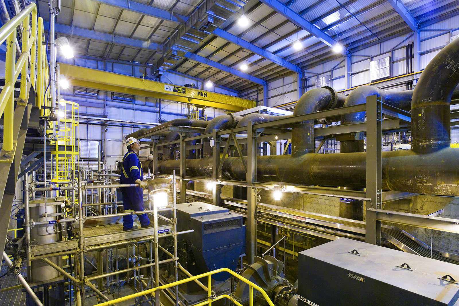 A person standing in a factory room looking at machines.