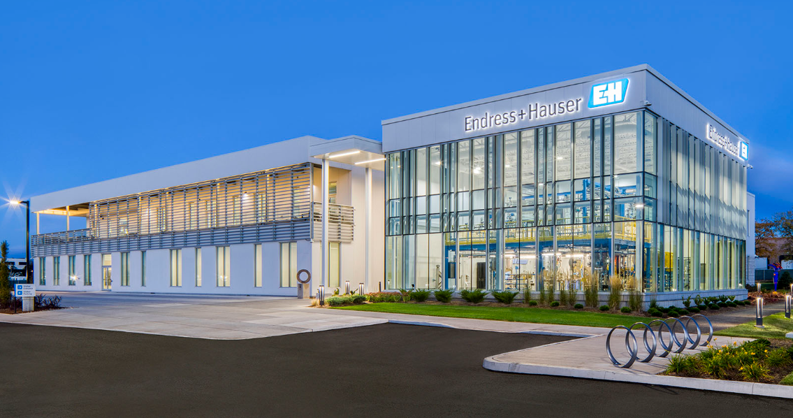 A large glass building with signs on top of it.