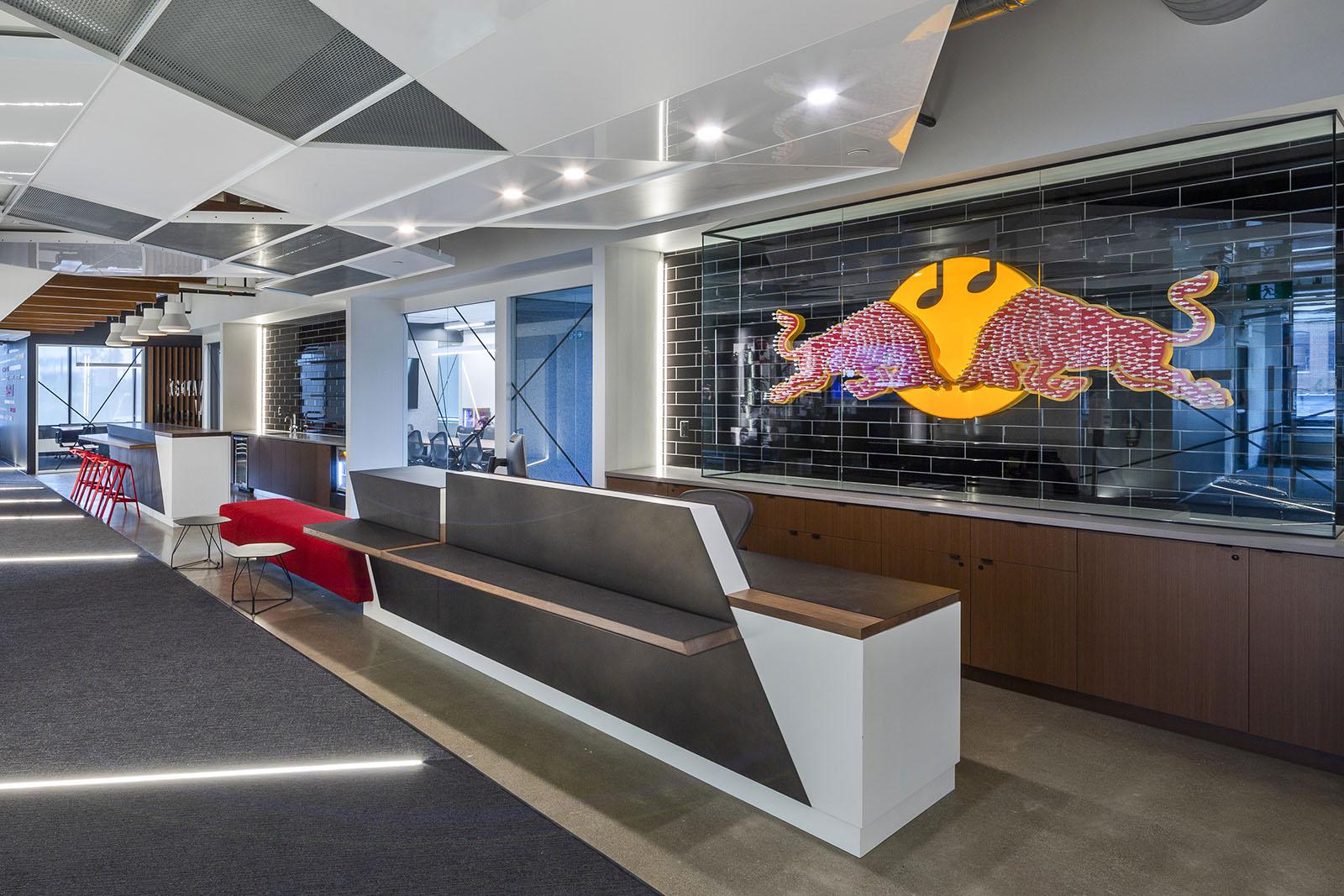 Image of a modern office space with accent lighting, a sitting area, and the logo of two bulls heads butting.