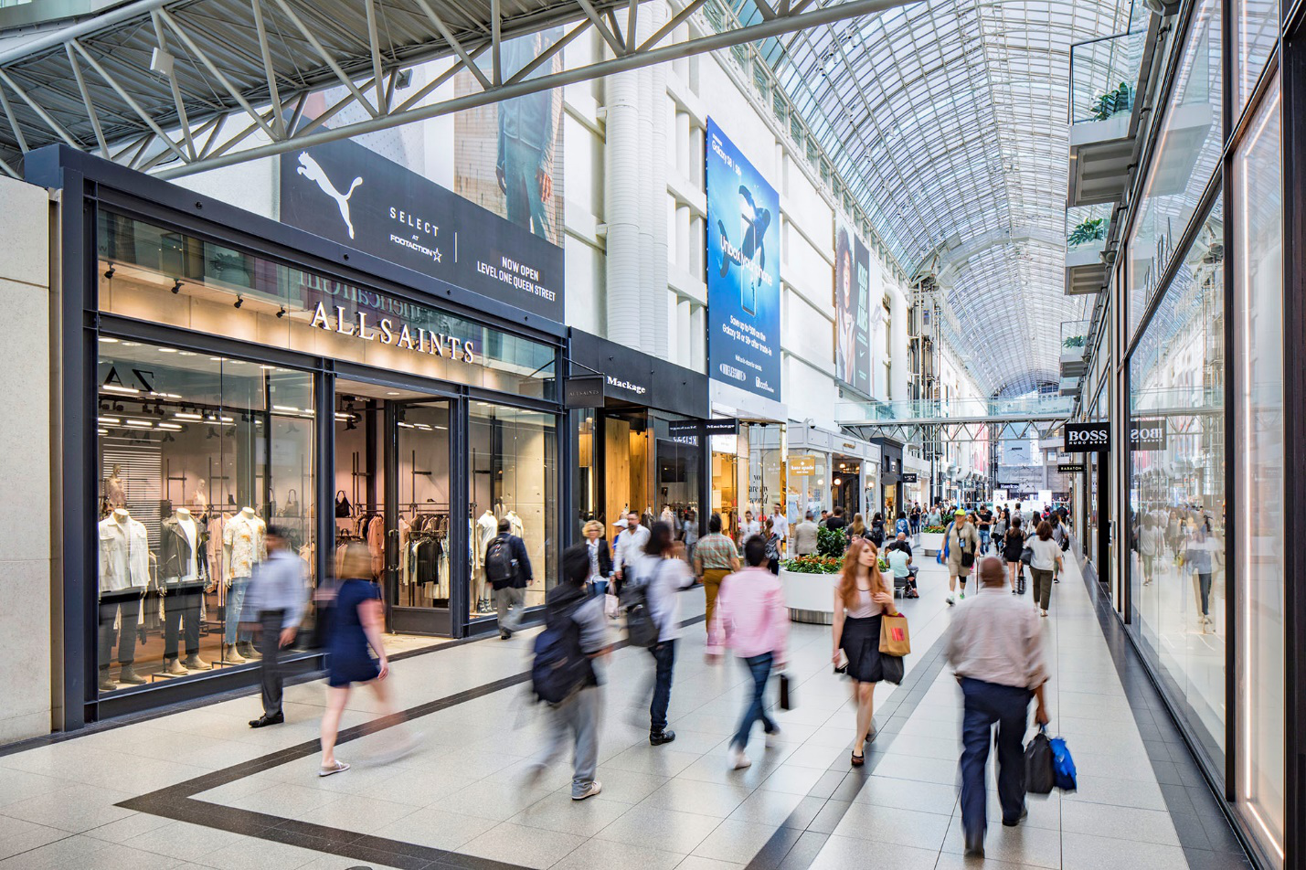 A large shopping mall with several people walking.