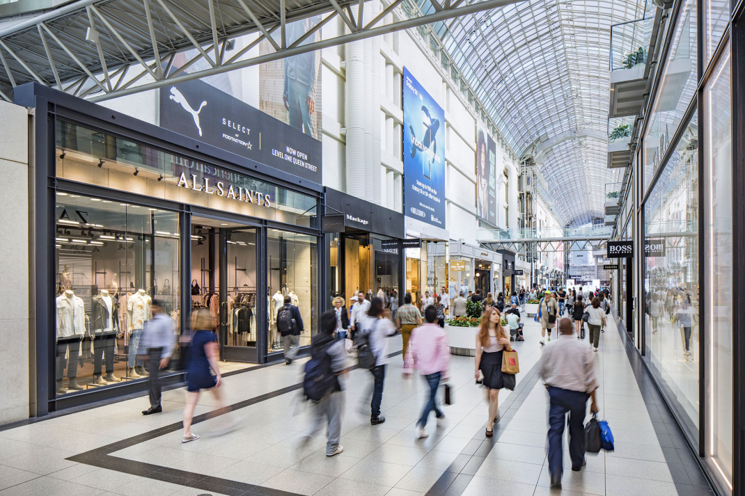 This photo shows a bunch of people walking inside a mall.